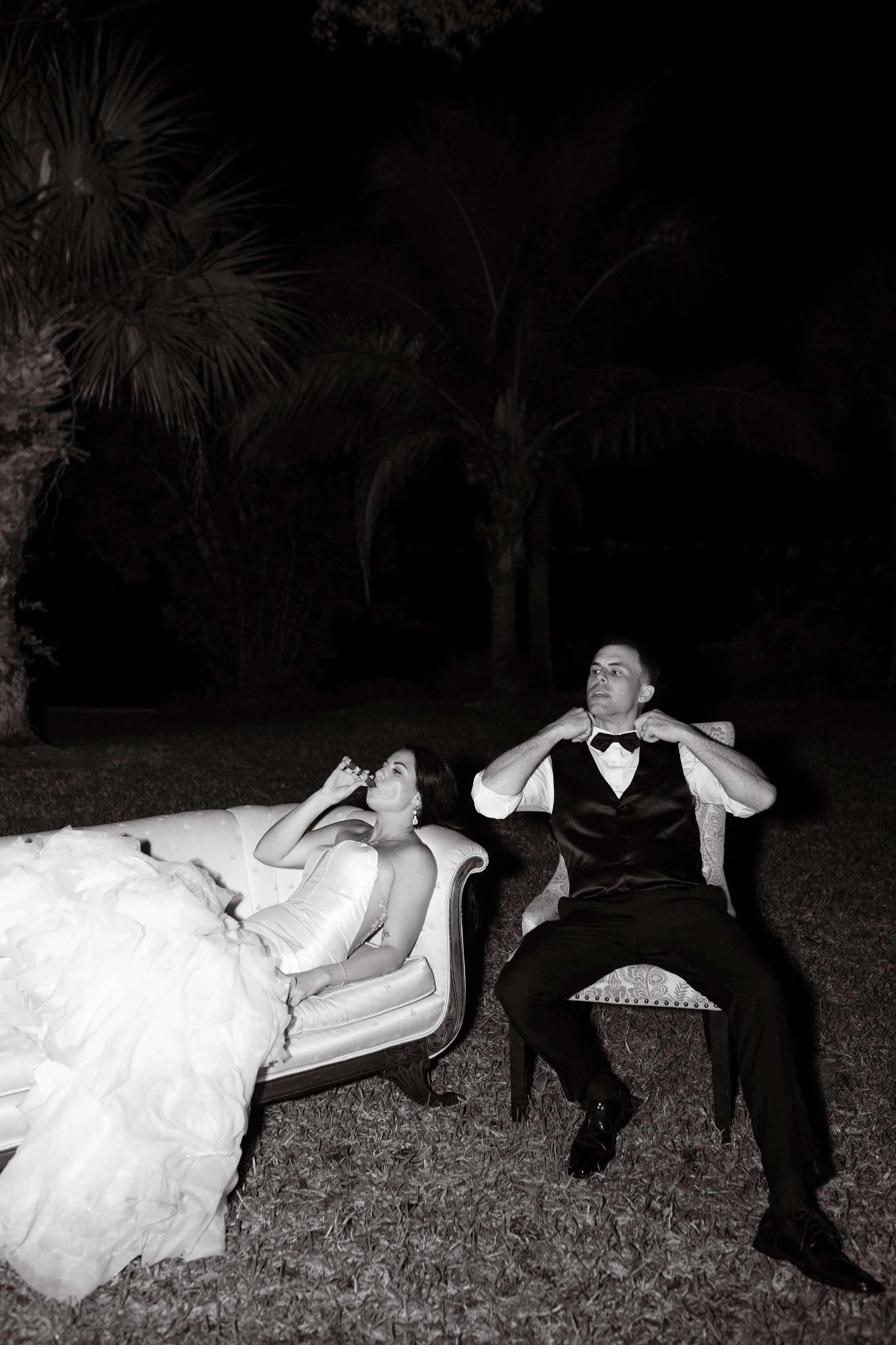 Black and white photo collage showing a relaxed bride in a strapless gown lounging on a vintage sofa while her groom in a tuxedo adjusts his bow tie, and below, the couple standing close together in an intimate outdoor moment.