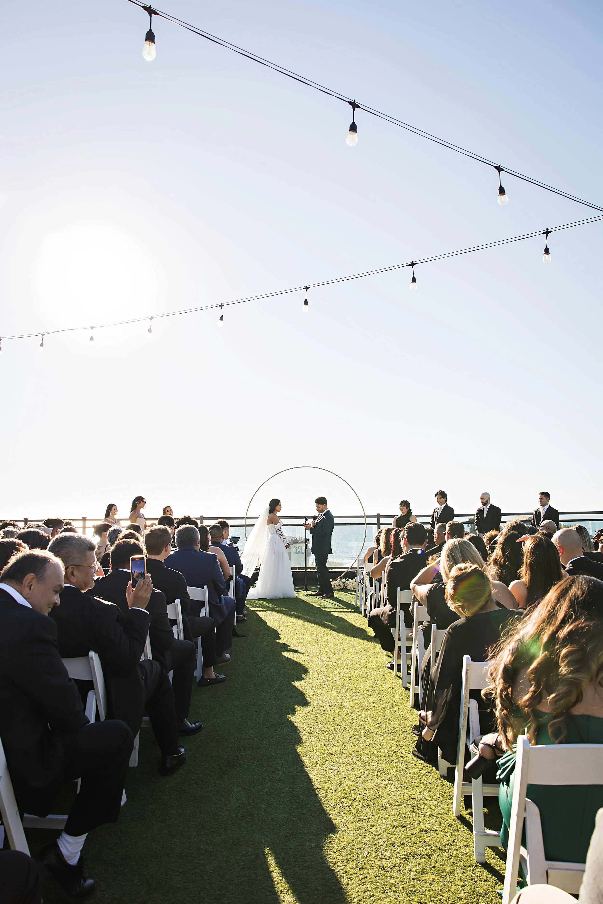 Wedding ceremony in November with stringlights on the rooftop of a St. Pete hotel.