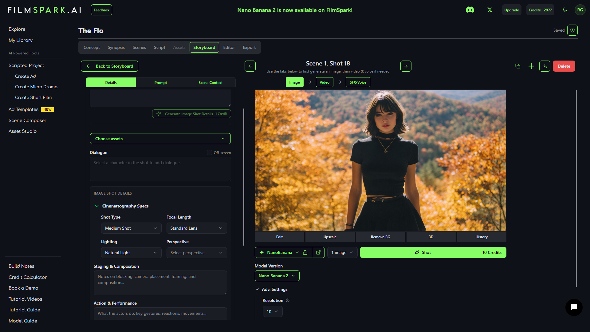 A young woman with dark hair wearing a black shirt and skirt standing outdoors during fall with orange and yellow trees in the background.