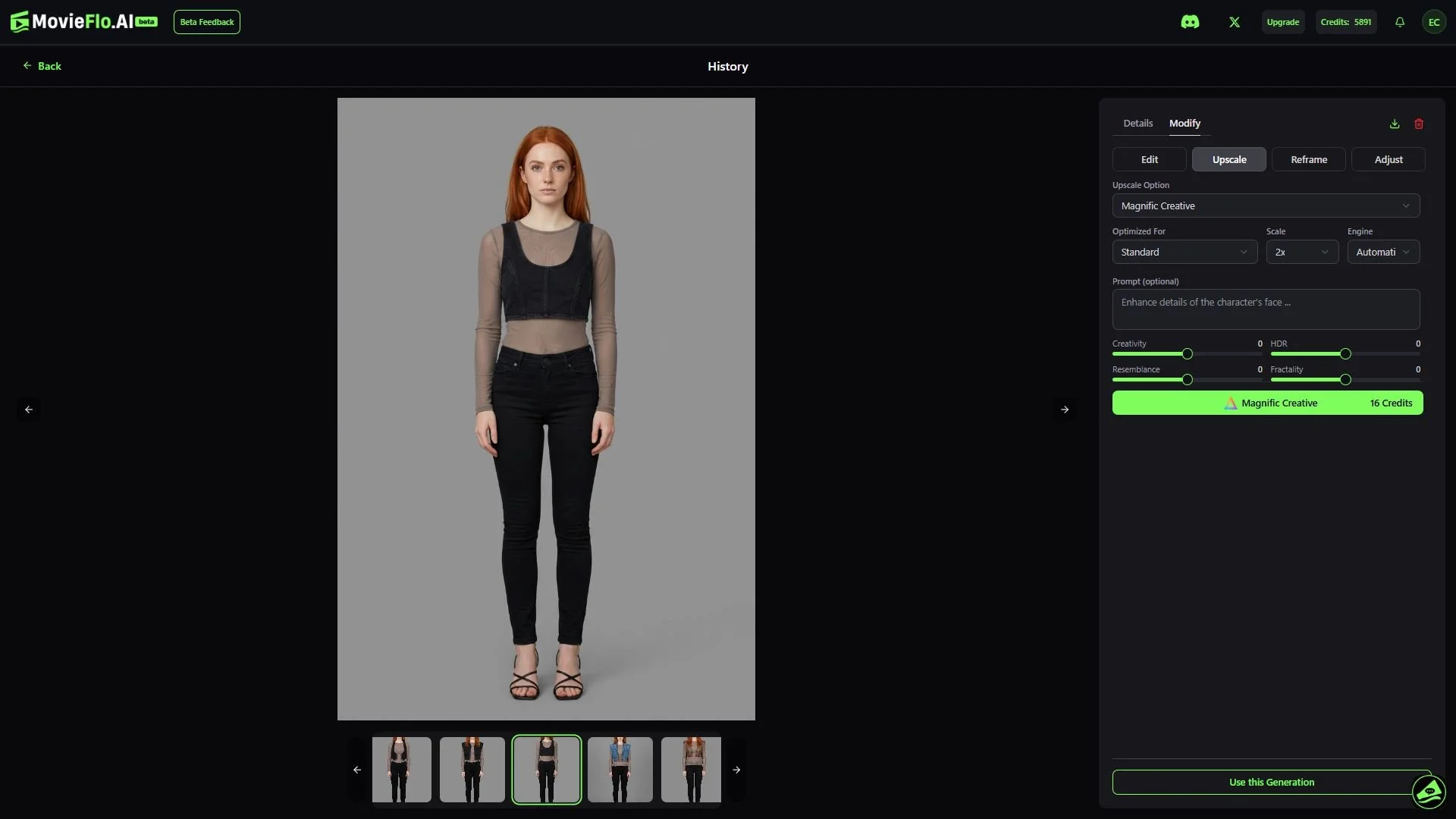A young woman with long red hair wearing a black crop top and black jeans, standing against a plain gray background.