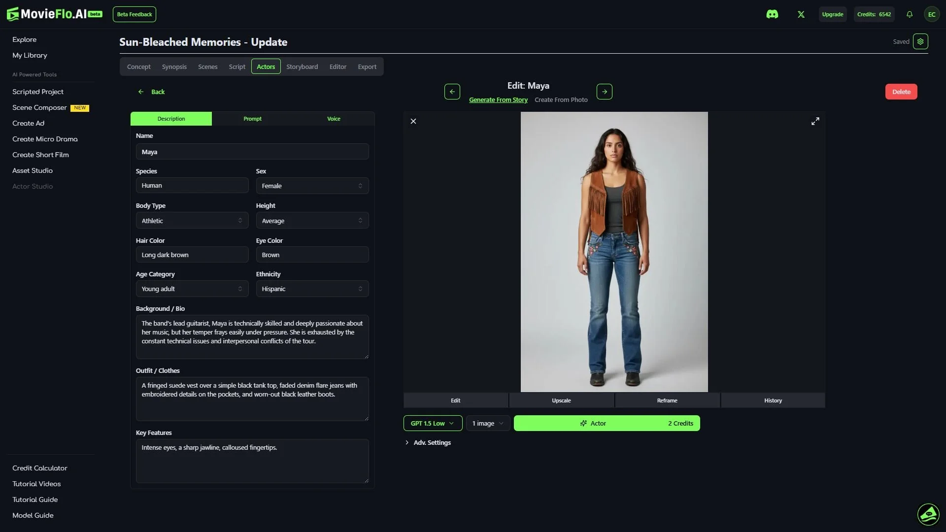 A woman with long dark brown hair standing against a plain light gray background. She is wearing a brown fringed vest over a black top, blue jeans with embroidered details, and black boots.