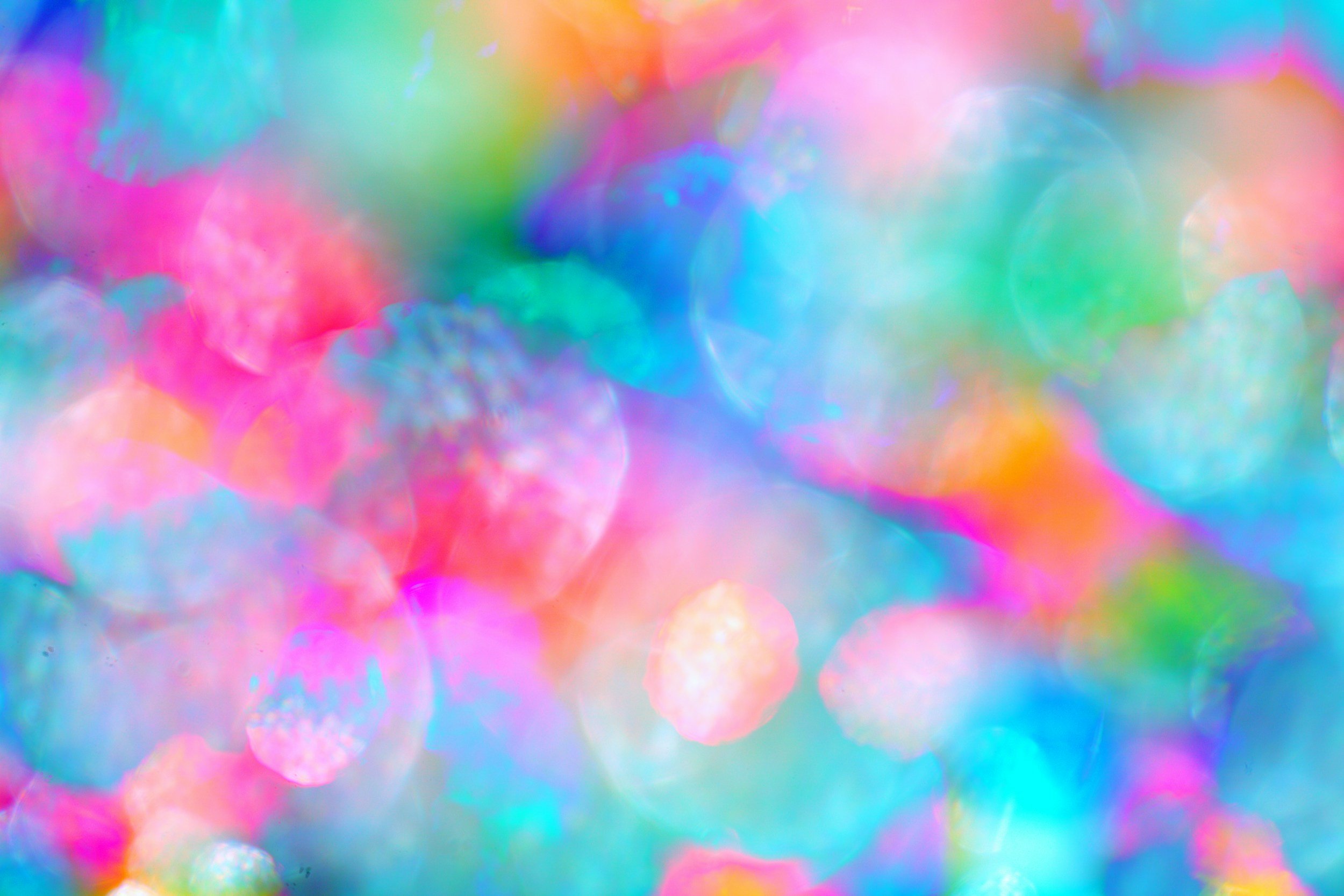 Abstract background of multicolored bokeh lights in pink, blue, green, orange, and purple hues.