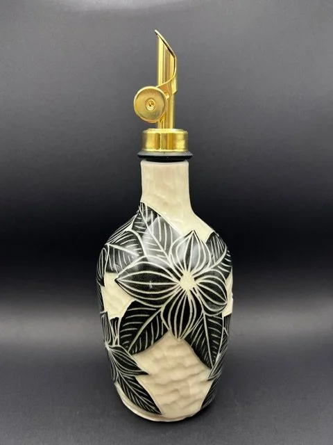 Decorative ceramic soap dispenser with black and white floral pattern and a gold pump top