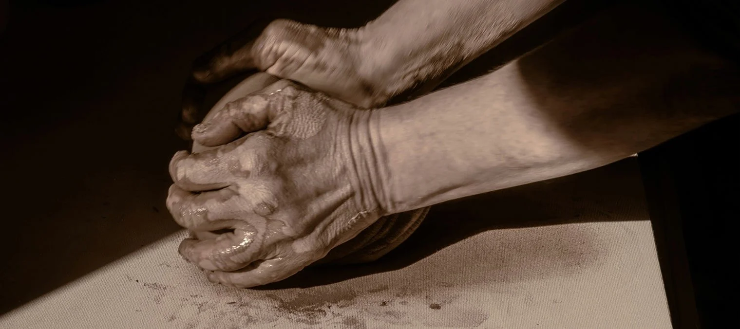 Close-up of hands pressing and shaping clay for handmade ceramic production
