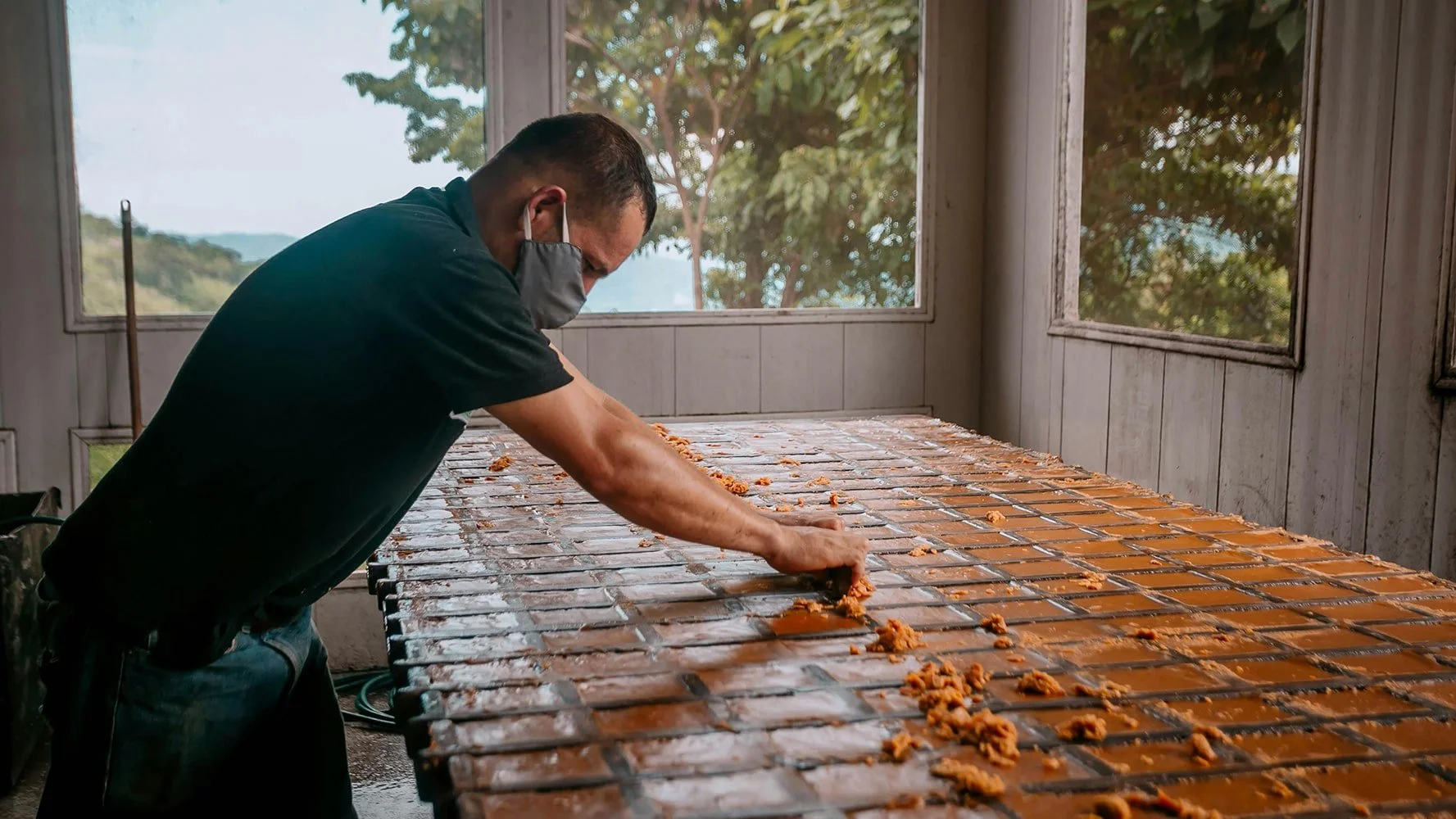 Craftsperson arranging handmade terracotta tiles on a worktable