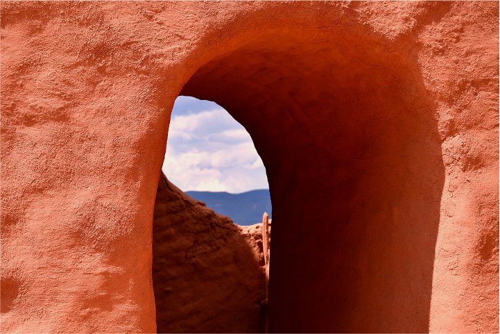 Terracotta architectural arch framing blue sky