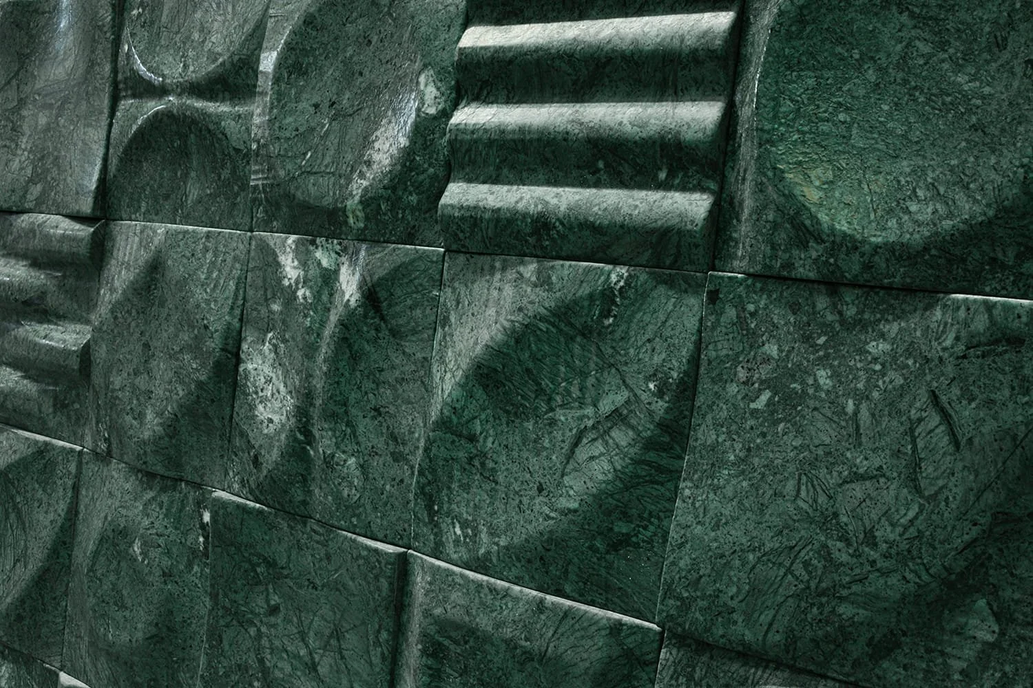 Deep green Verde India stone tile featuring handcrafted carved patterns and dimensional architectural detailing