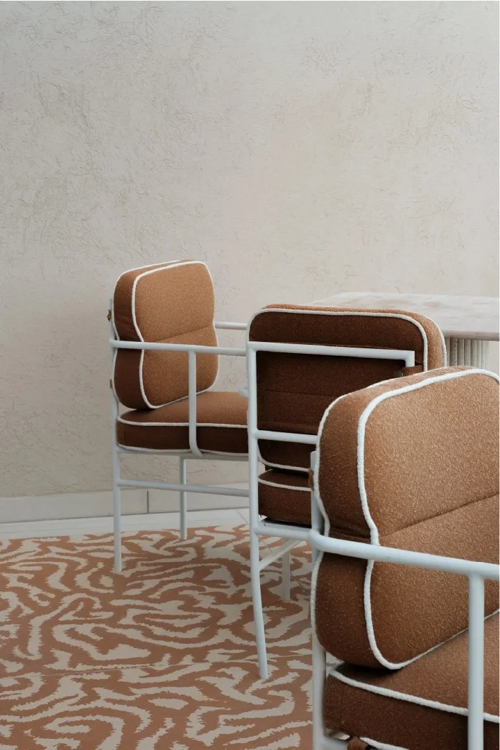 Sculptural chairs with terracotta geometric patterned floor