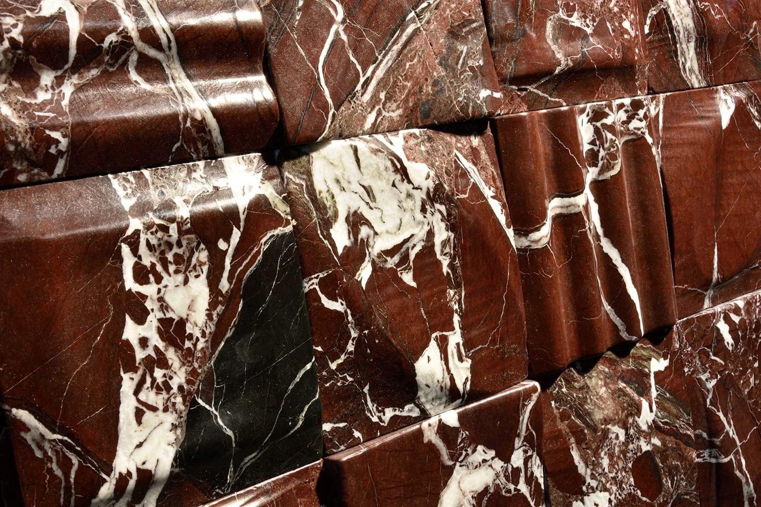Handmade Bordeaux Royal stone tile showcasing sculptural carving and dramatic natural stone movement