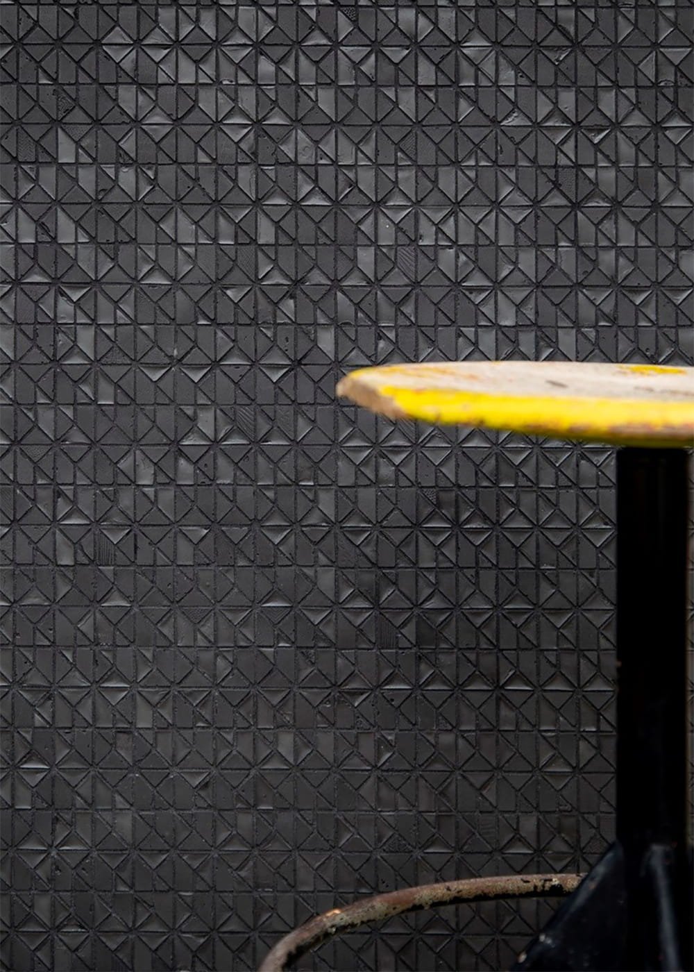 Dark recycled glass mosaic tile geometric triangle pattern textured surface detail