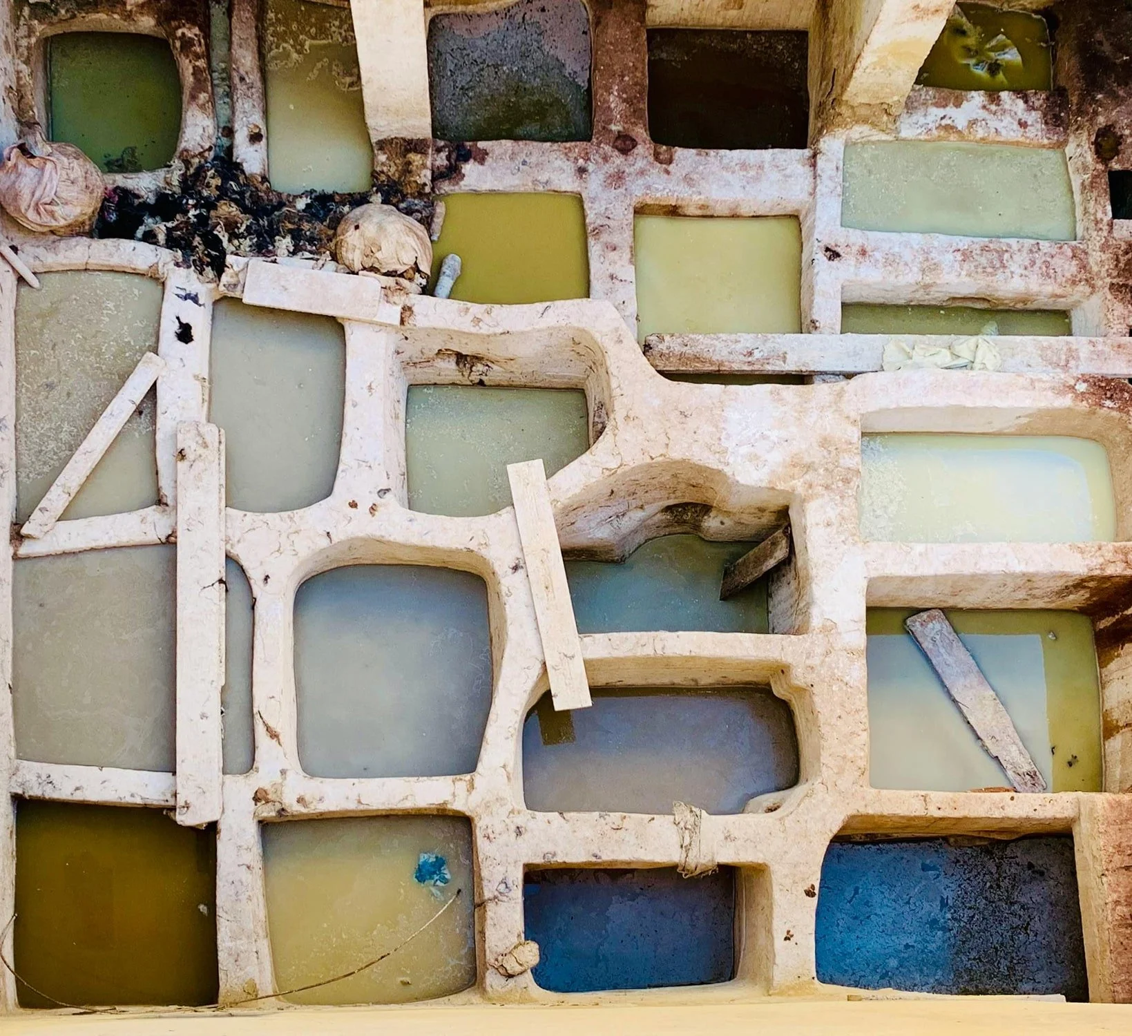 Artisan dye vats in earthy green, blue and ochre tones