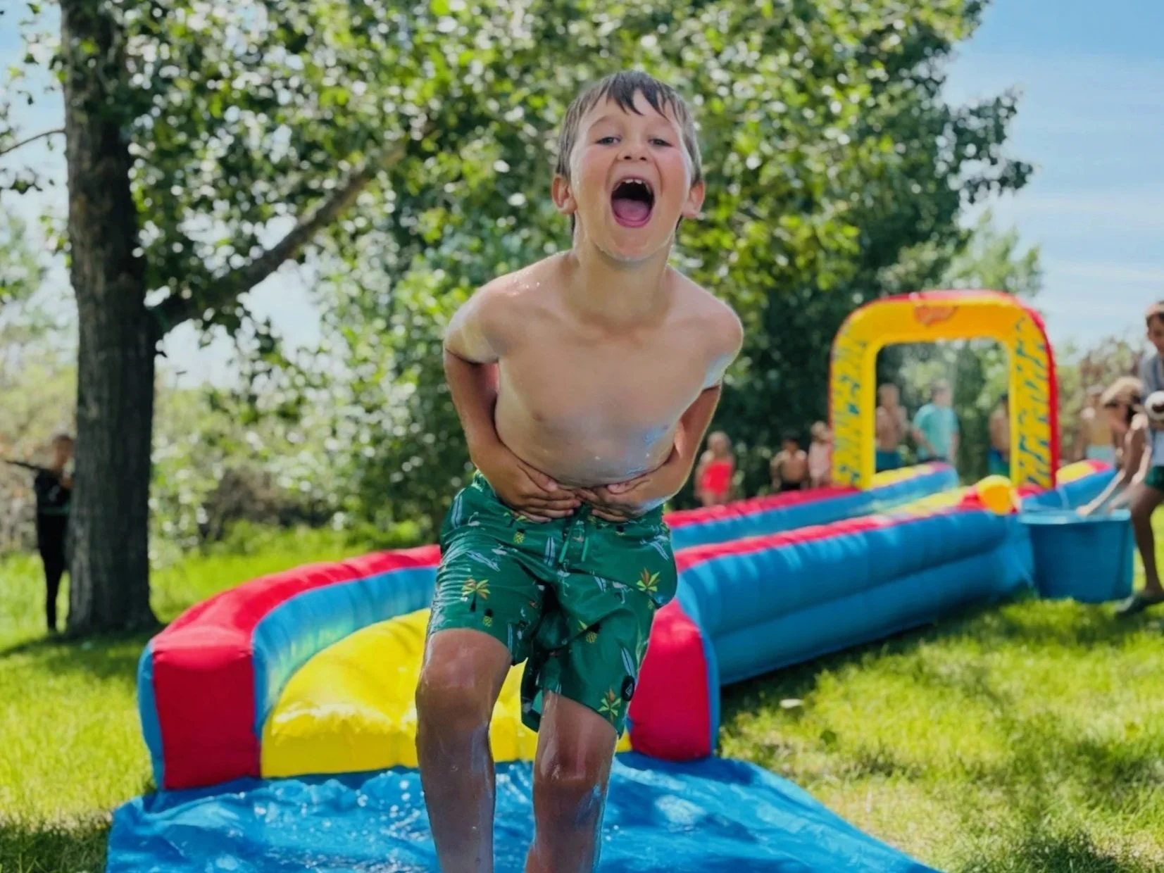 Young boy excited after playing on a slip and slide