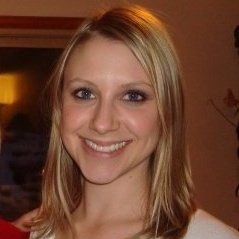 A smiling woman with blonde hair, in an indoor setting.