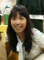 Young girl with long black hair smiling in a yellow room