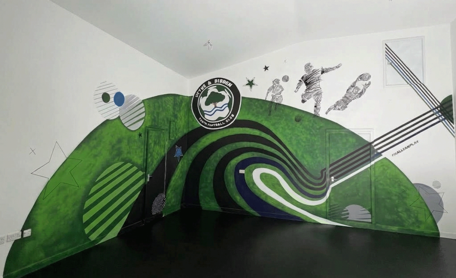 Indoor sports room with green and black decorative wall featuring football theme, logo, and illustrations of players and stars.