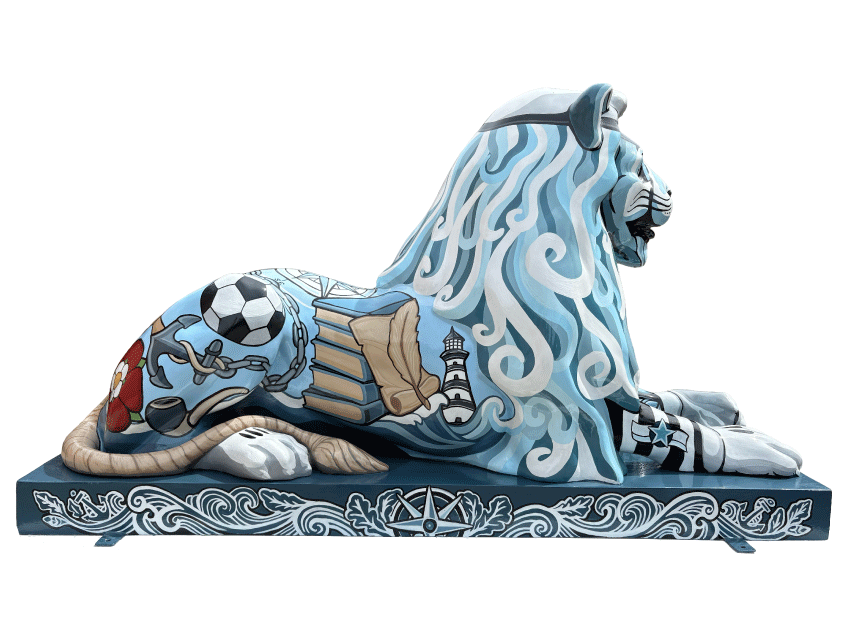 A decorative sculpture of a lion with ocean wave details, painted in shades of blue, white, and black, with elements like a soccer ball, books, a lighthouse, and a naval insignia.