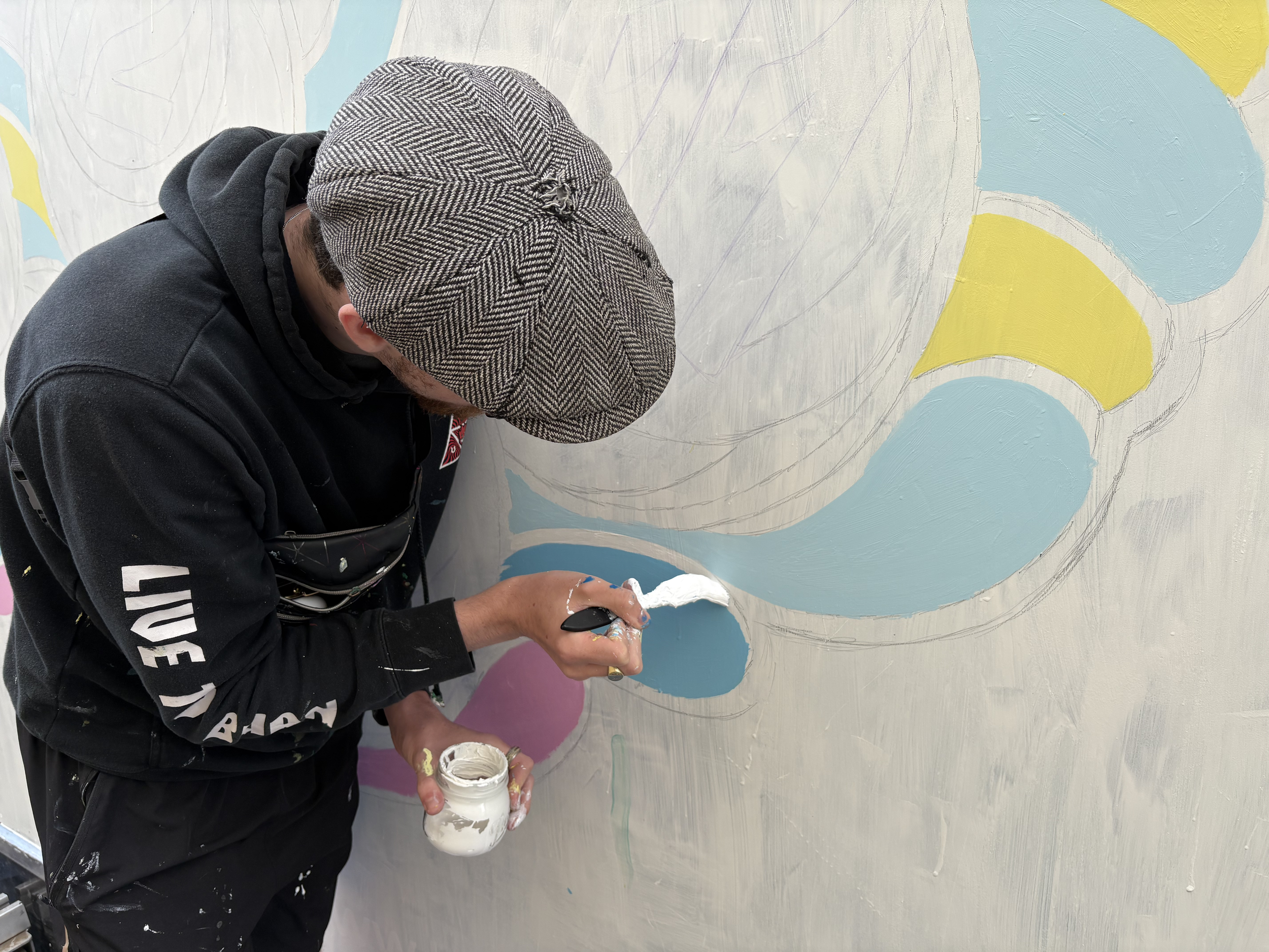 Aidan Jack Waldron Hand-painting corporate wall branding featuring company logo in Hampshire office lobby.