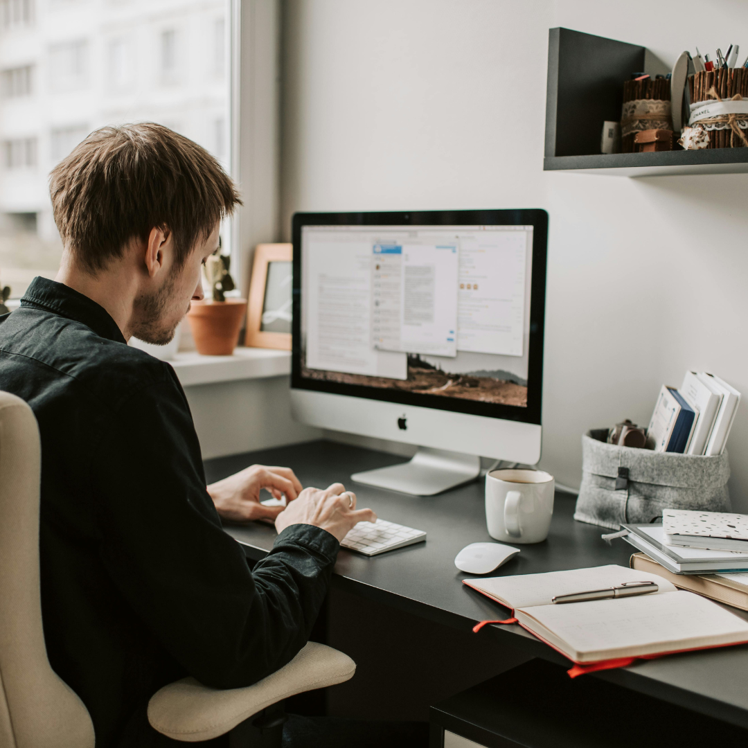 A person working at a desktop computer in a home office