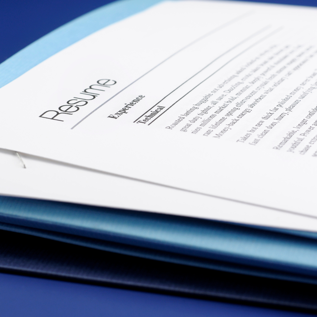 A printed resume resting on a blue folder