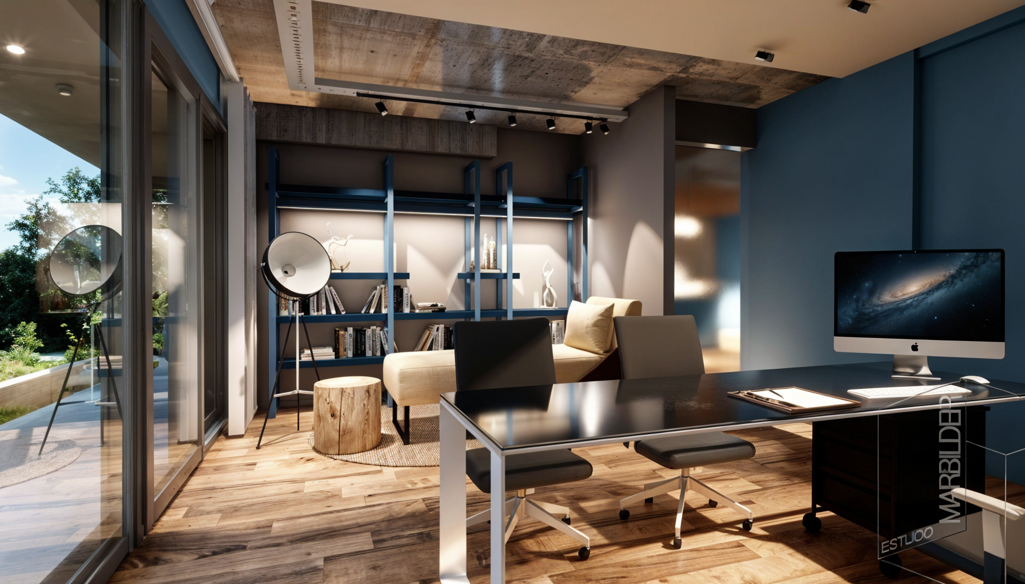 Una oficina moderna con escritorio negro, silla negra y computadora iMac en una mesa. En el fondo, una sala de lectura con estanterías azules, una lámpara de pie, una silla beige y decoración.