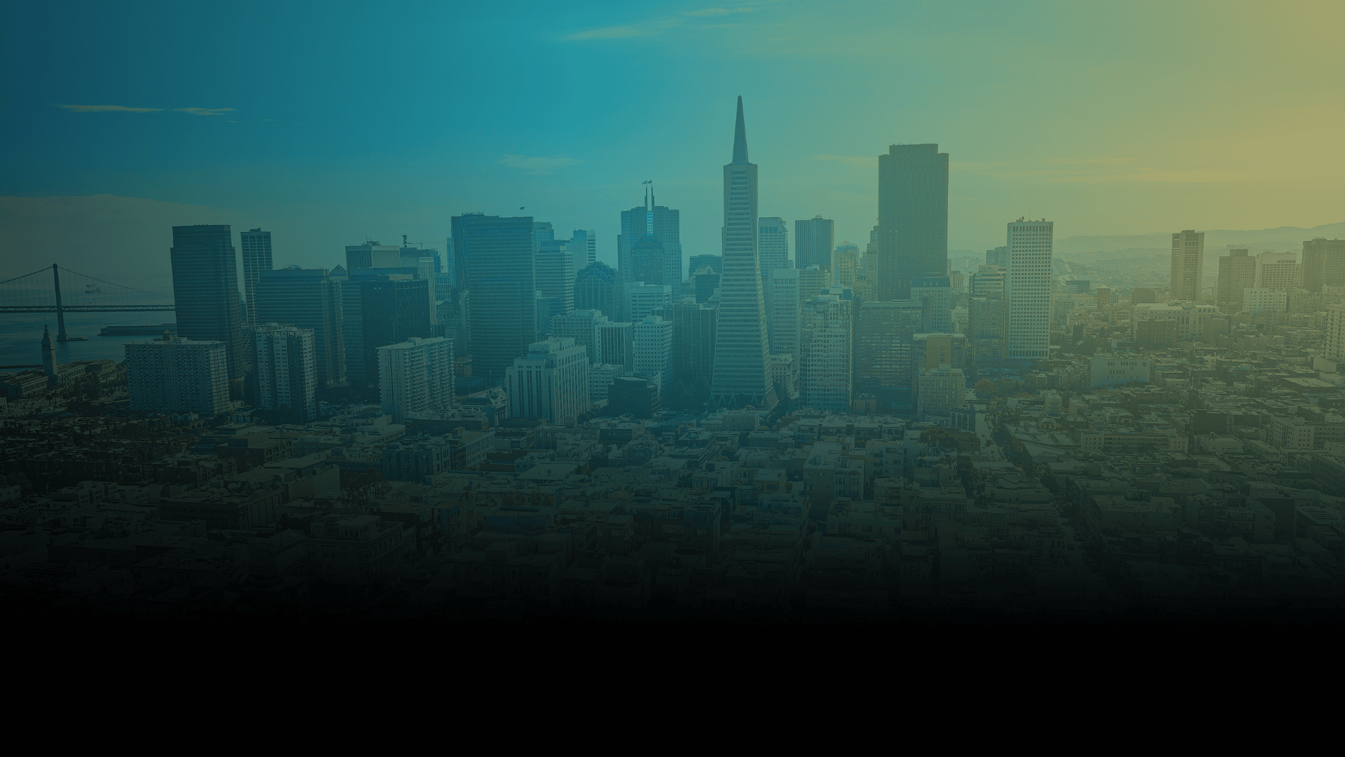 City skyline with skyscrapers including the Salesforce Tower, with a bridge in the background, under a hazy sky.