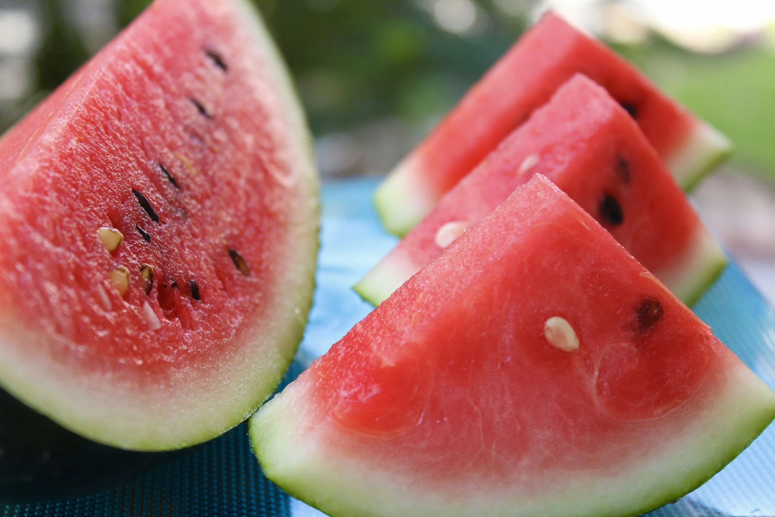 Slices of fresh watermelon on a blue surface.