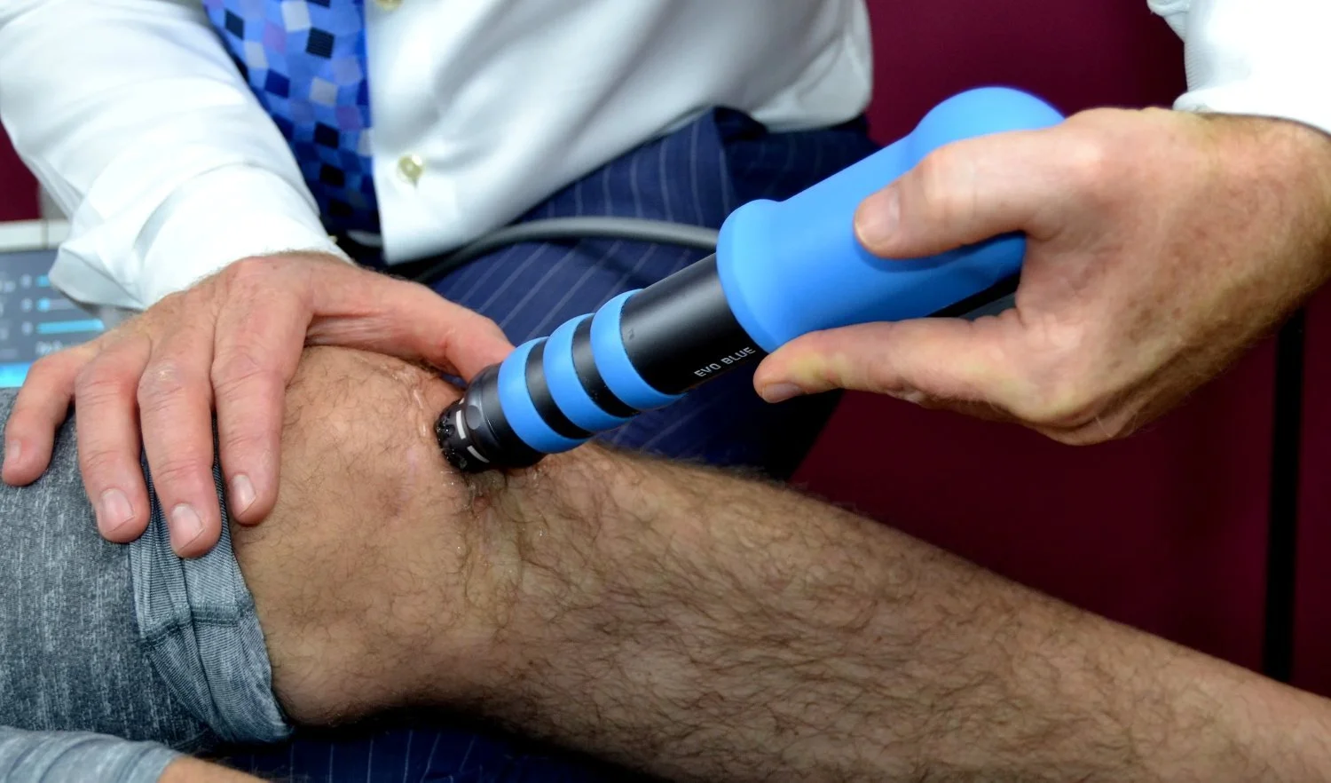 A photo of a patient receiving shockwave therapy for squatting knee pain treatment in Hillsboro, OR