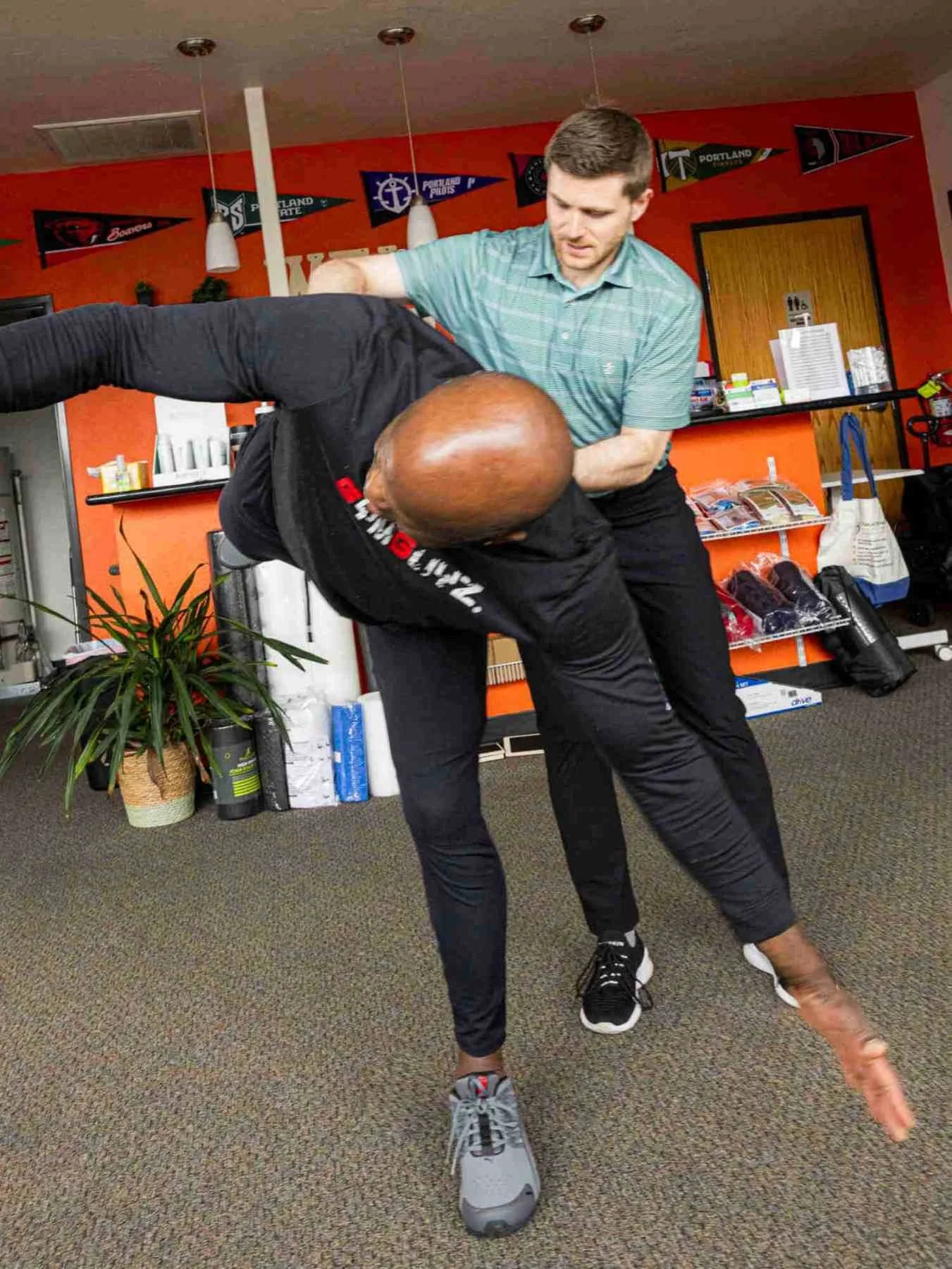 A physical therapist helps guide a patient's hips while performing hip airplanes - an advanced hip stability and strength exercise.