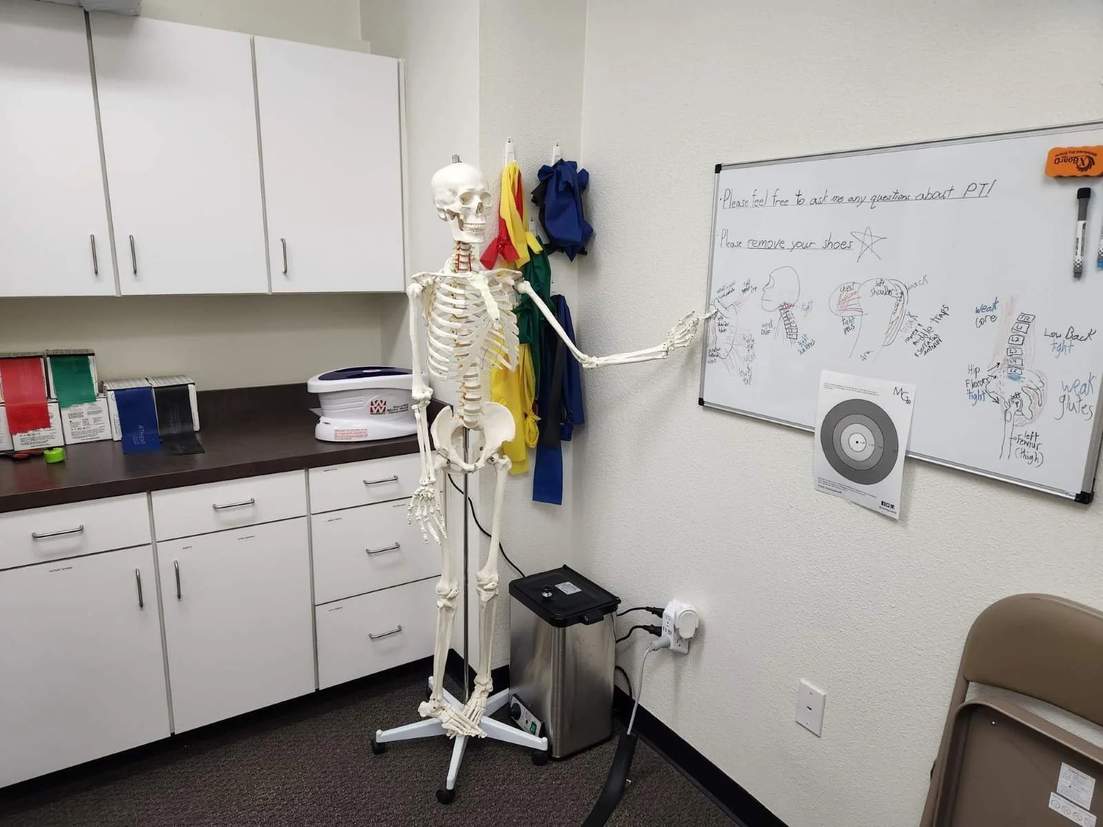 Winston is at a whiteboard in a physical therapy exam room ready to educate patients on anatomy and kinesiology. Education is a primary foundation of our sports medicine PT approach.