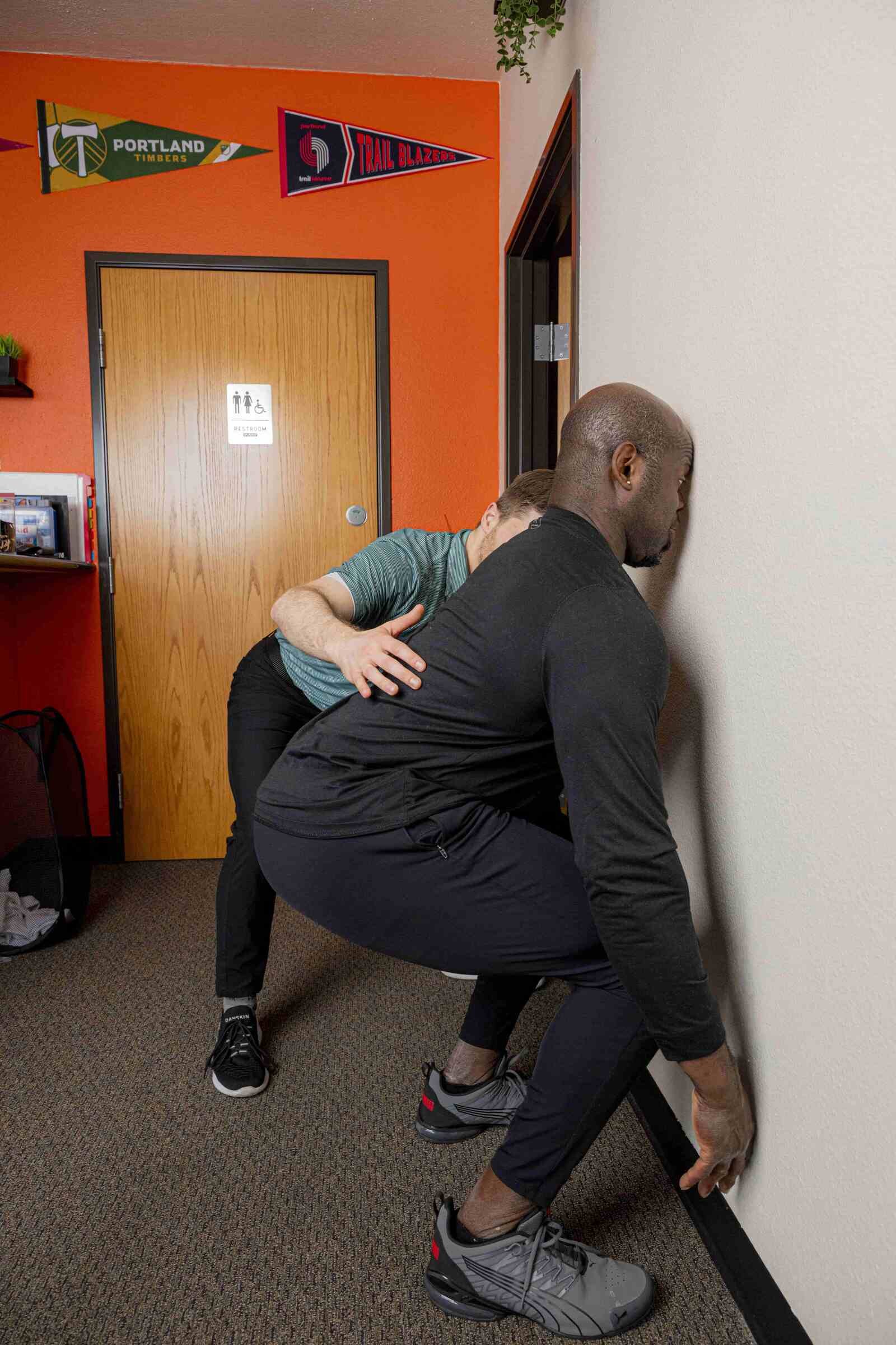 Physical therapist working on squatting technique as part of rehab for knee pain with squats in Hillsboro, Oregon