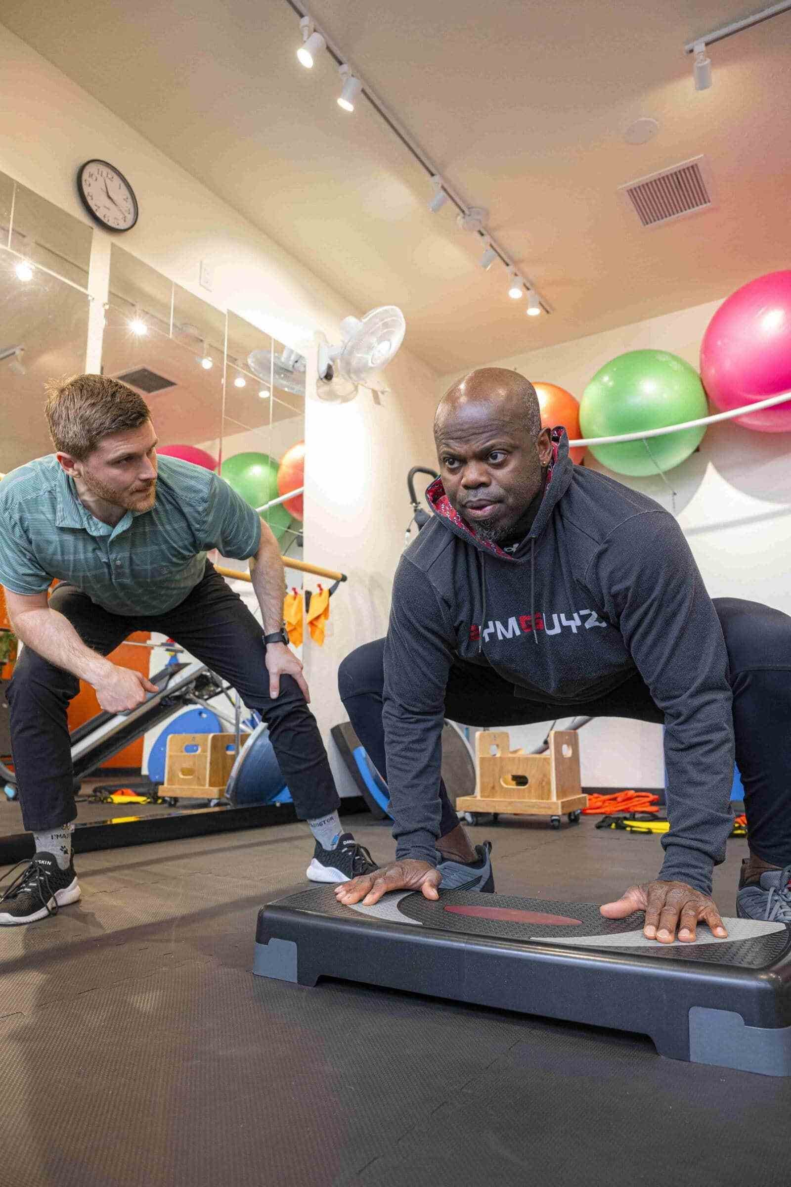 Dr. Ben assessing the form of a patient whine in the main gym area of the TVPT clinic