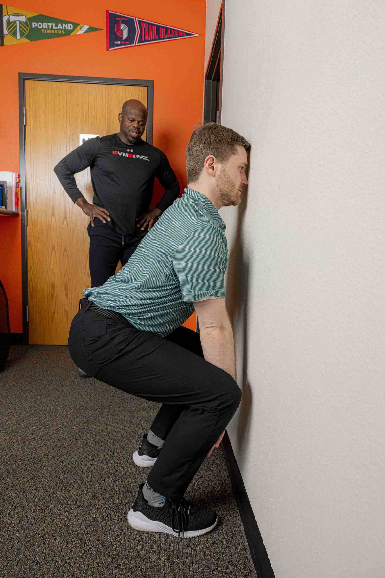 A Doctor of PT performing a squat variation to reduce low back pain and knee pain at Tualatin Valley Physical Therapy in Hillsboro, OR