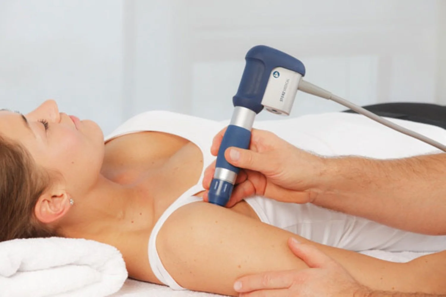 A photo of a patient receiving shockwave therapy for shoulder impingement treatment in Hillsboro, OR