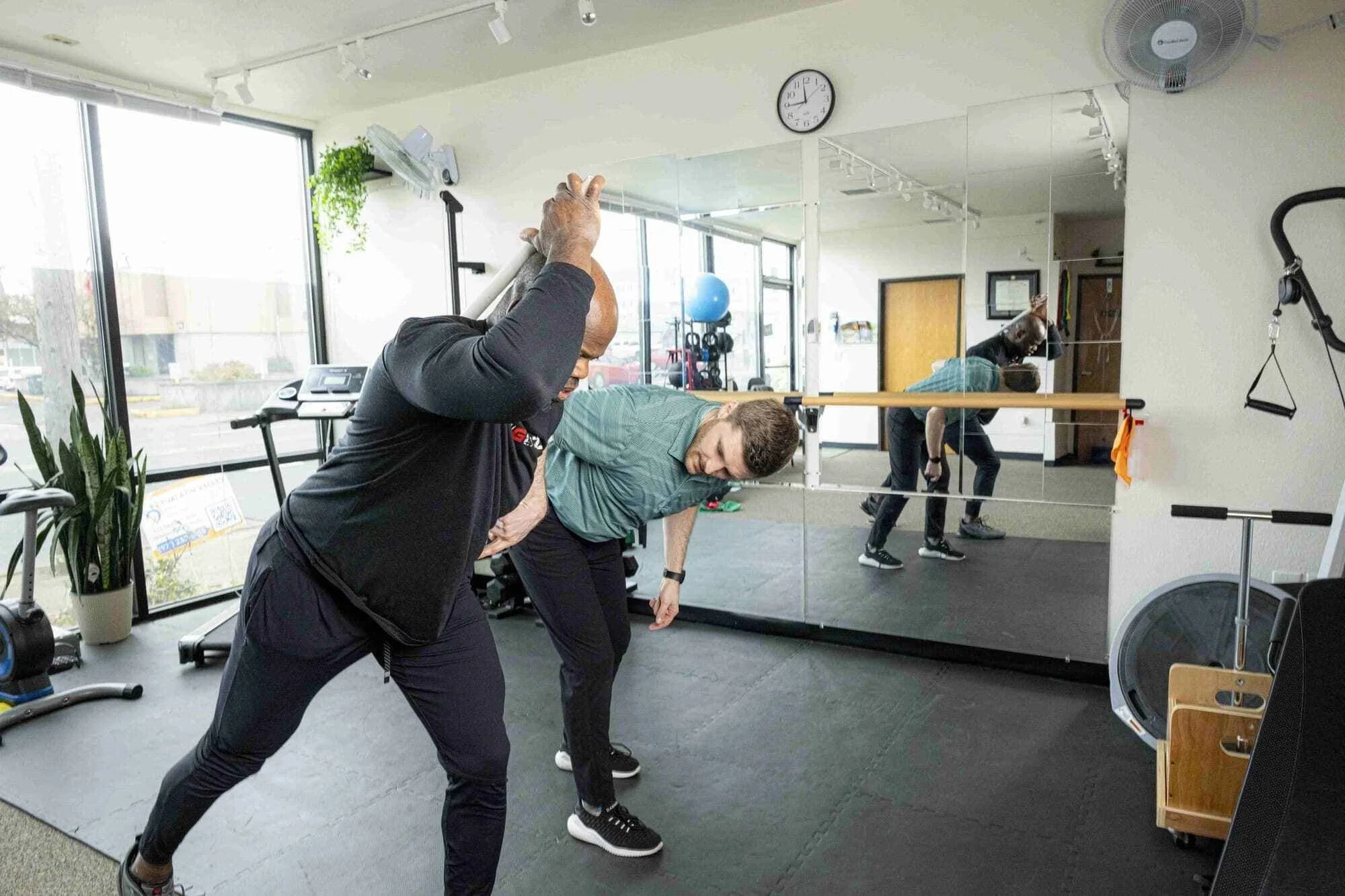 Dr. Ben assessing a patient's ability to perform a sliding single-leg hip hinge for running performance