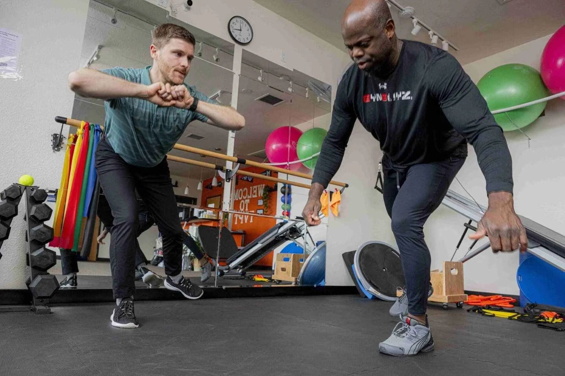 A physical therapist working with a patient on their balance, motor control, and strengthening their gluteal muscles and core to reduce and prevent low back pain.