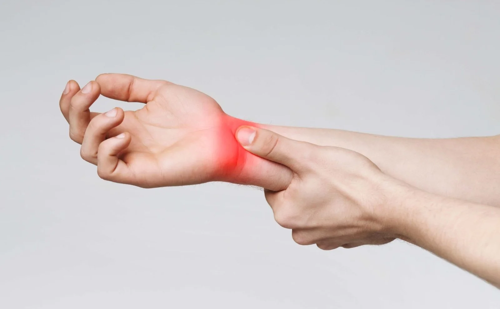 A person holding their right forearm in pain from carpal tunnel wrist pain.