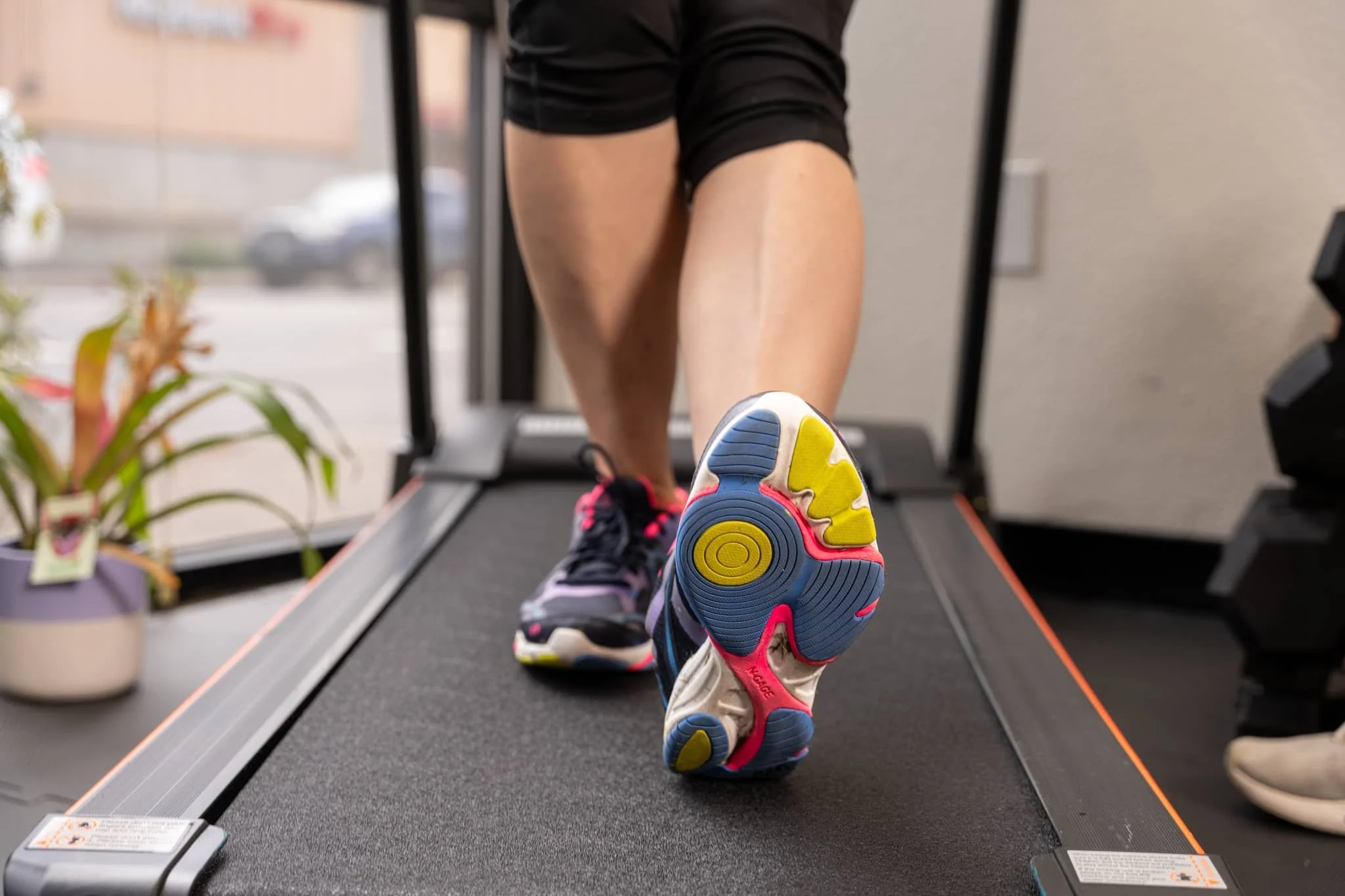 A physical therapist has a patient walk backward on a treadmill as a functional test.