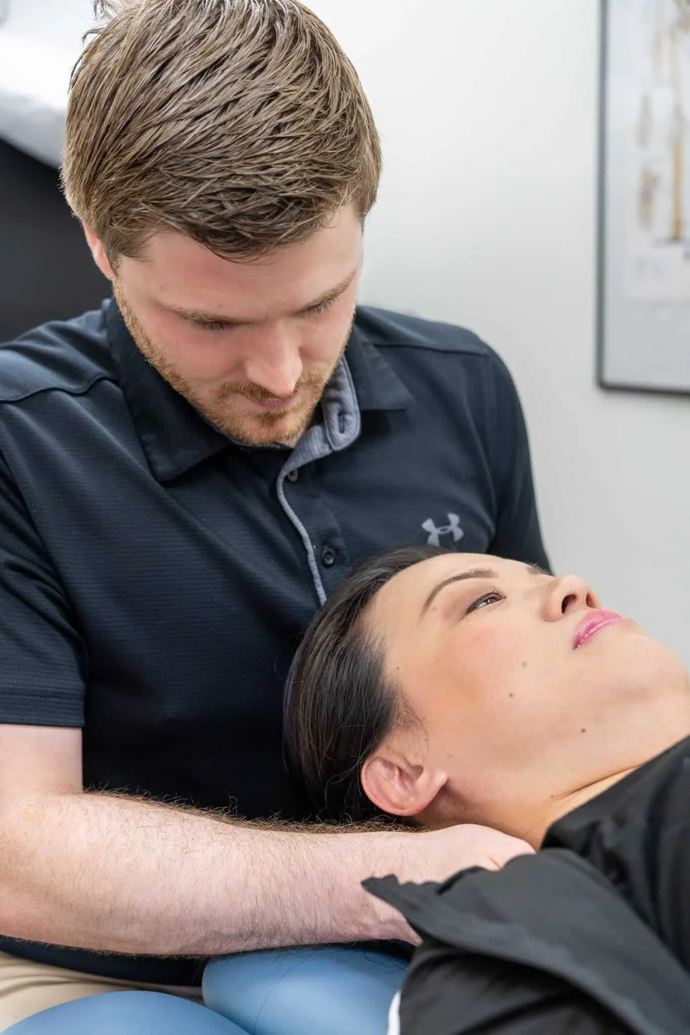 A physical therapist evaluating a patient's neck post-concussion.