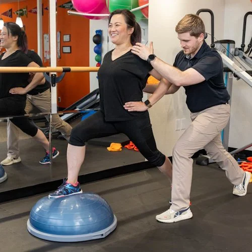 A physical therapist working with a patient on strength training for runners