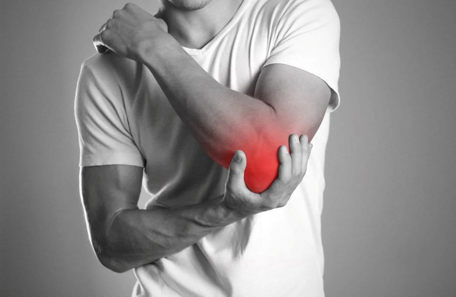 A photo of someone grabbing their elbow because it hurts.