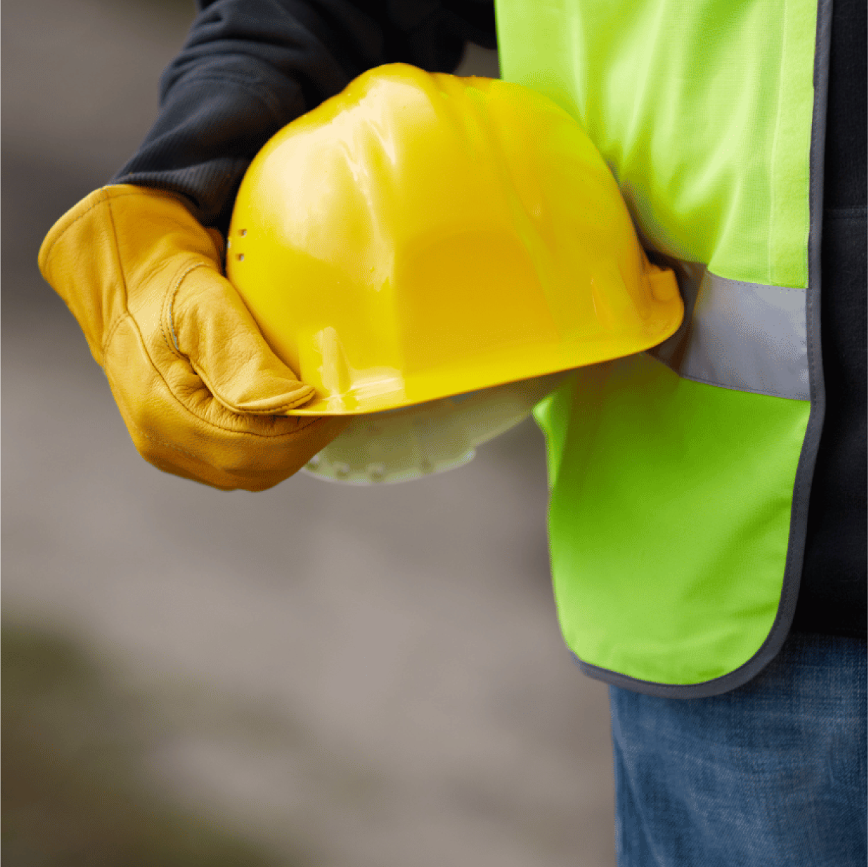 Close up of construction worker with arm around yellow hard hat