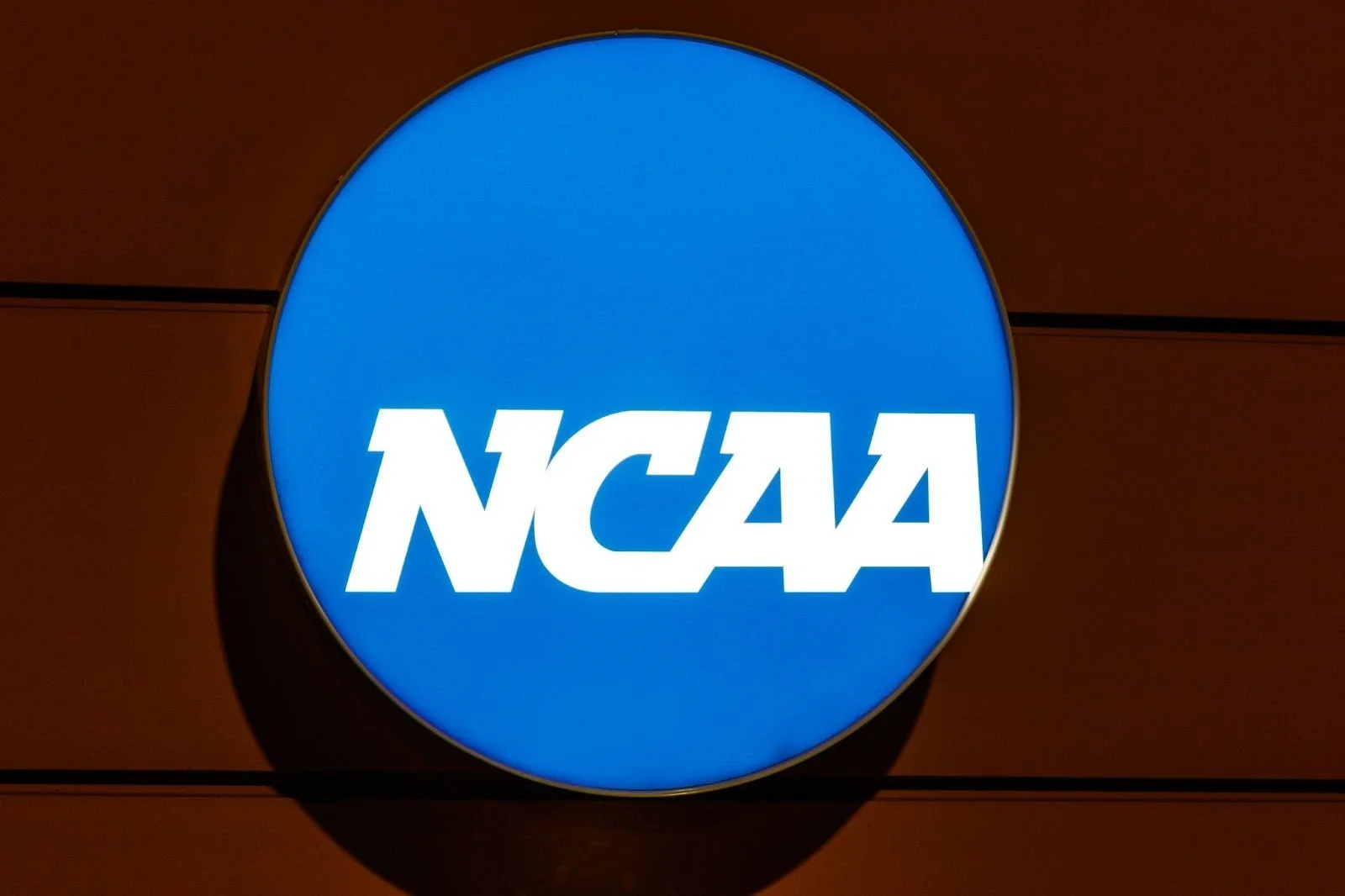 A blue, circular sign displaying the white NCAA logo.