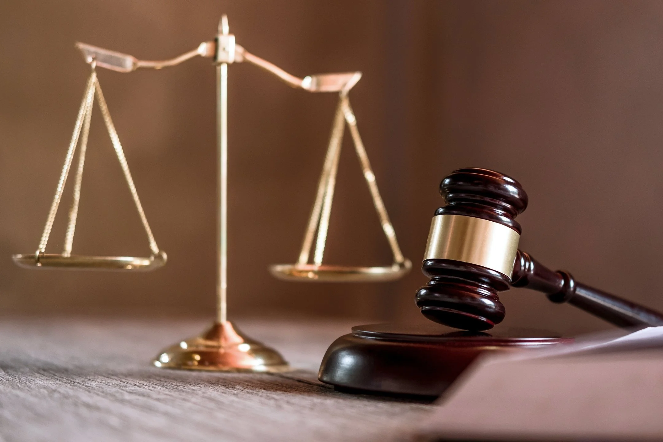 Judge's gavel with justice scales on dark background