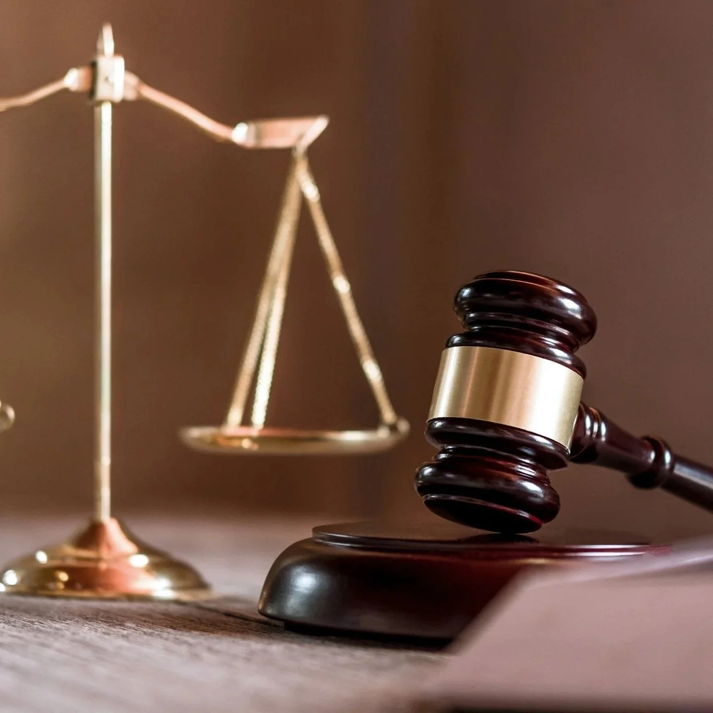 Judge's gavel with gold justice scales on dark studio background