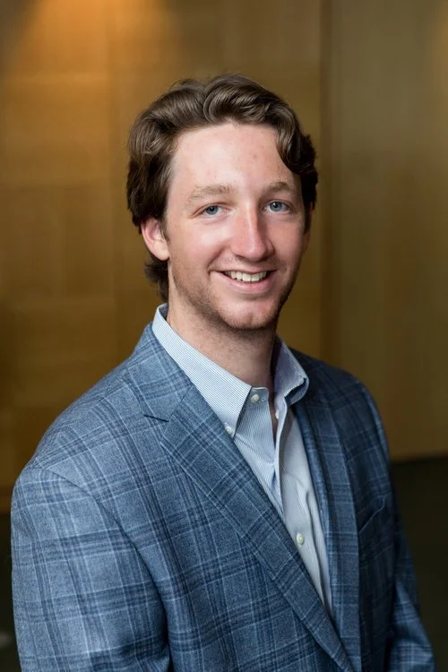 Professional headshot of man wearing suit, smiling