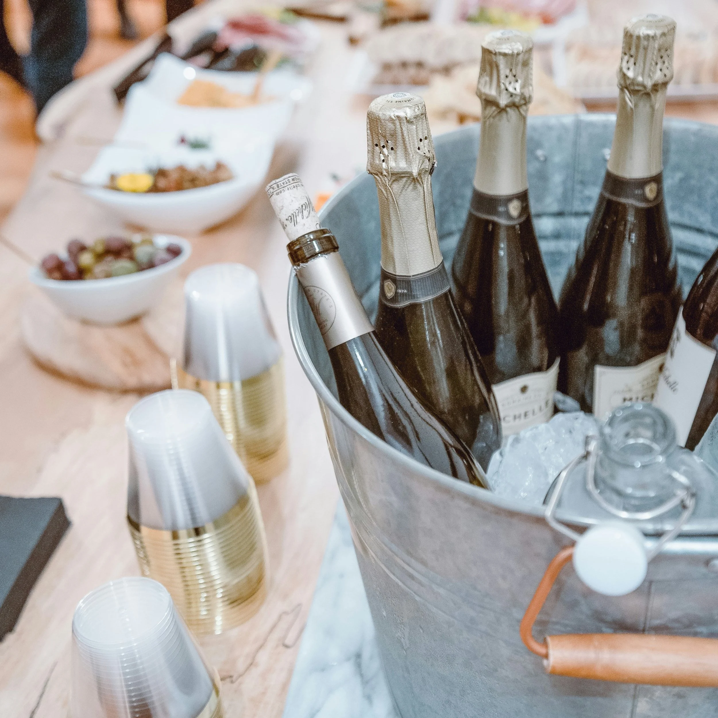 Chilled bottles of champagne in an ice bucket on a table set for a celebration.