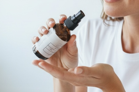 woman holding body oil container