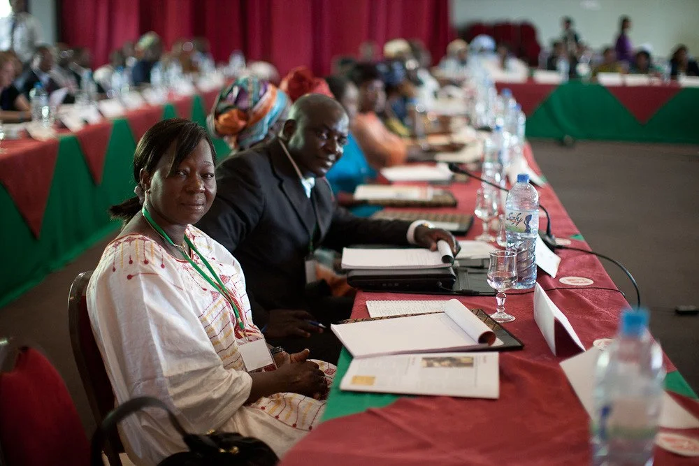 photo of a panel of people sitting at a table with clipboards