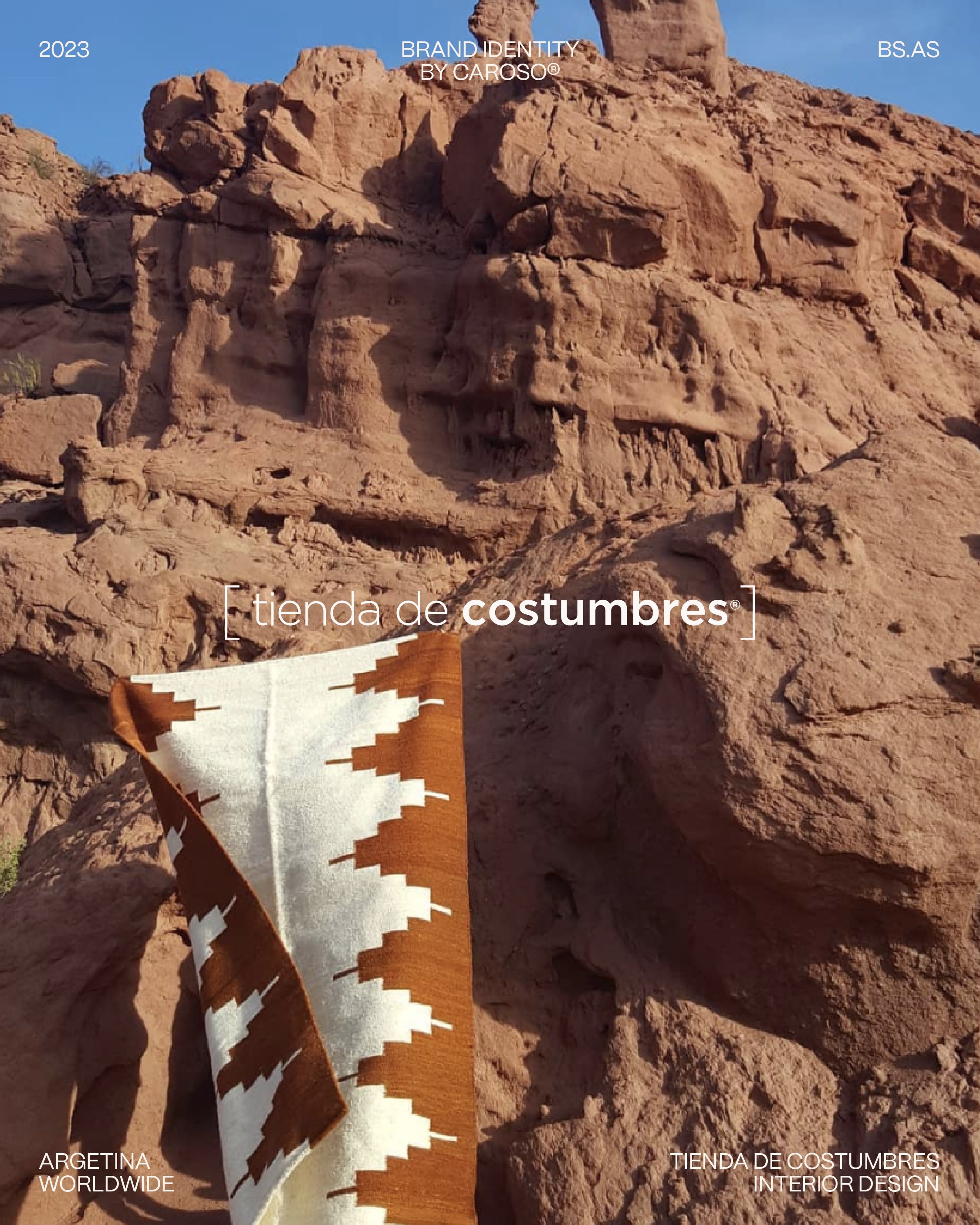 Paisaje rocoso con un textil estampado sobre las piedras, con una sobreimpresión de diseño gráfico que muestra la identidad de marca de Tienda de Costumbres @tiendadecostumbres.