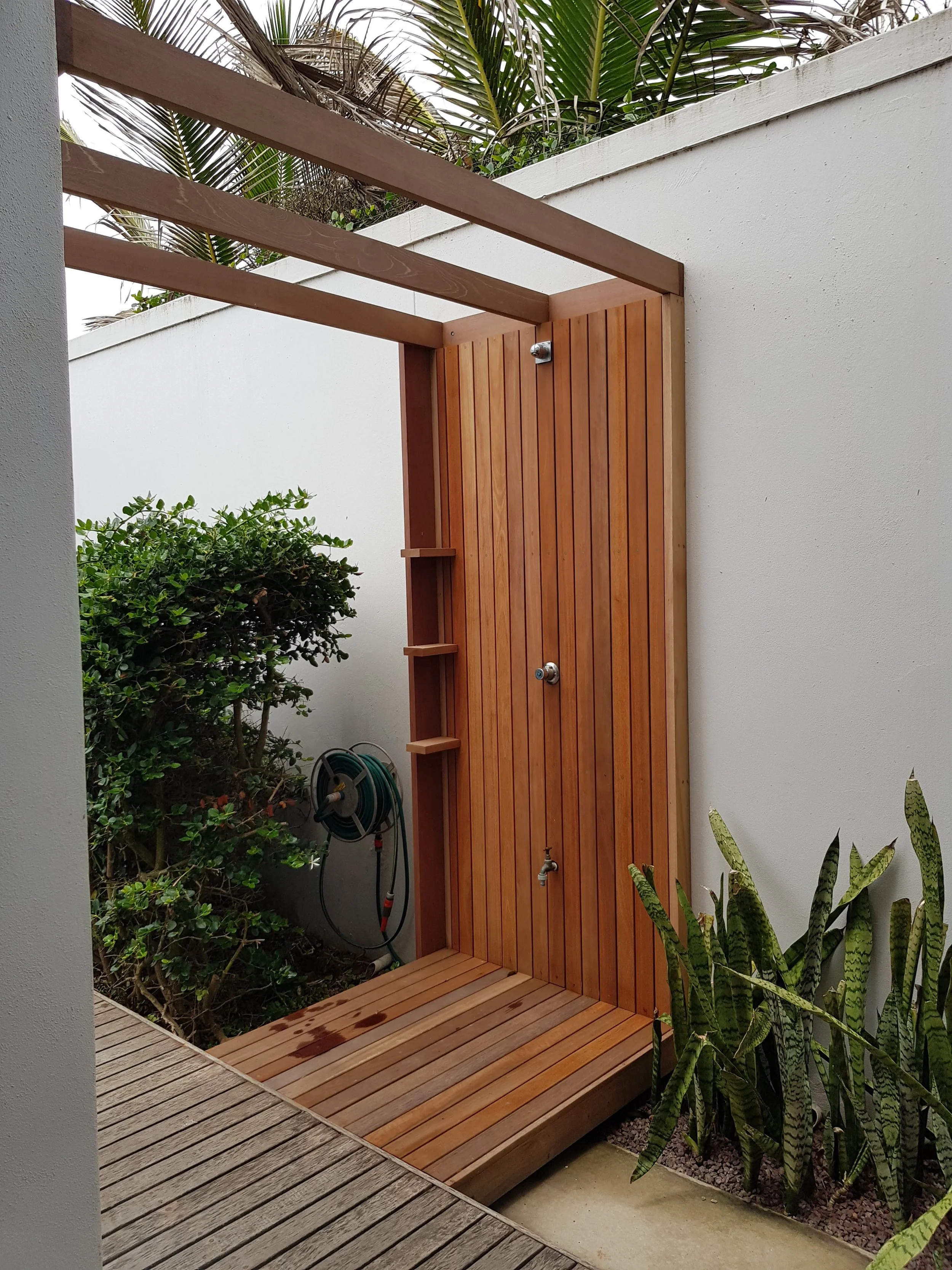 An outdoor shower for an after beach days rinse off set in a Casaurina beach home, the timber deck is a feature